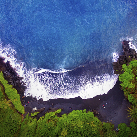 wave on the shore of a black sand beach