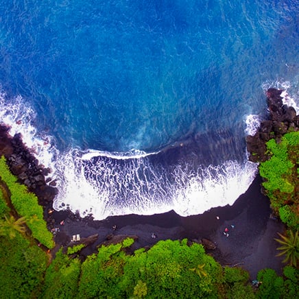 wave on the shore of a black sand beach